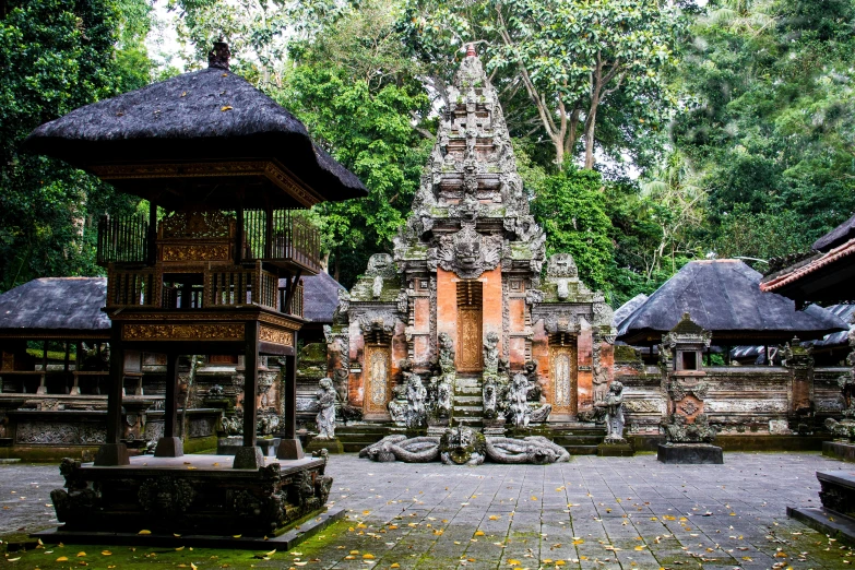 a group of stone statues with grass and trees in the background