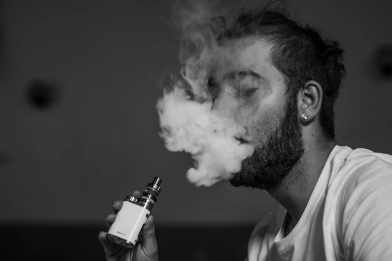 a man smoking soing with an electronic cigarette in his mouth