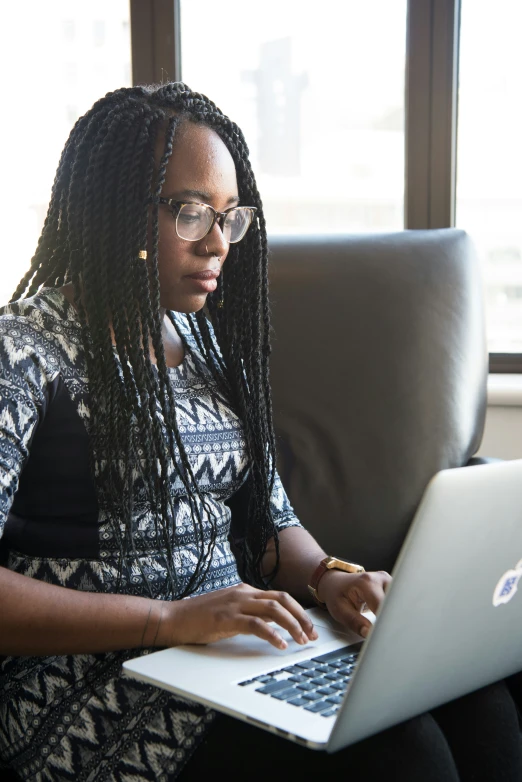 the woman is typing on her laptop at the table