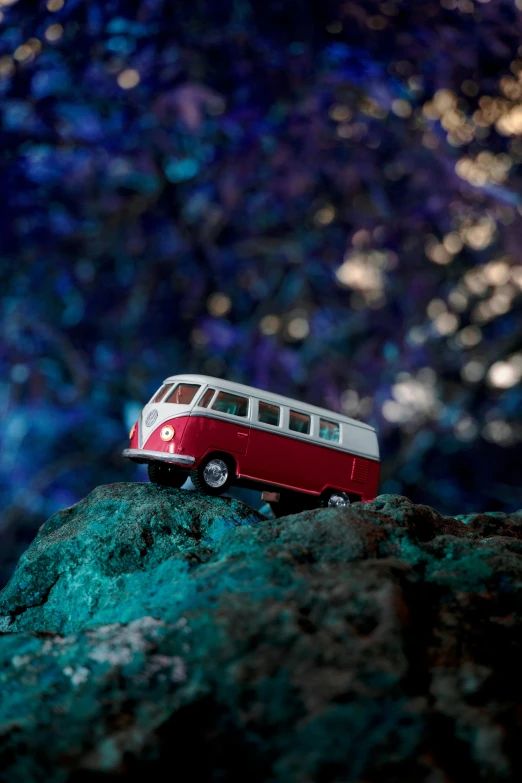 a red and white bus parked on top of a rock
