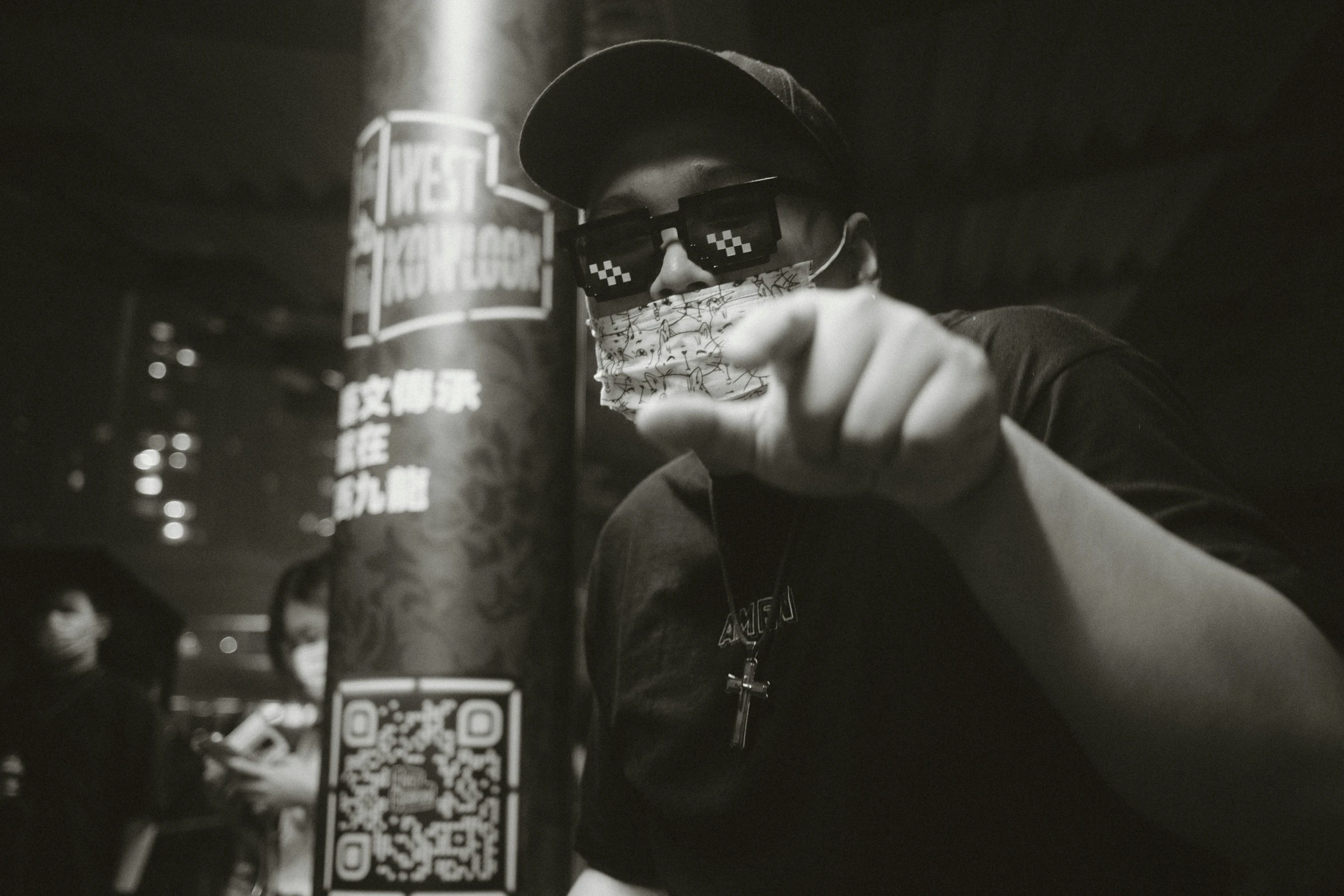 man standing next to sign holding a cup in hand