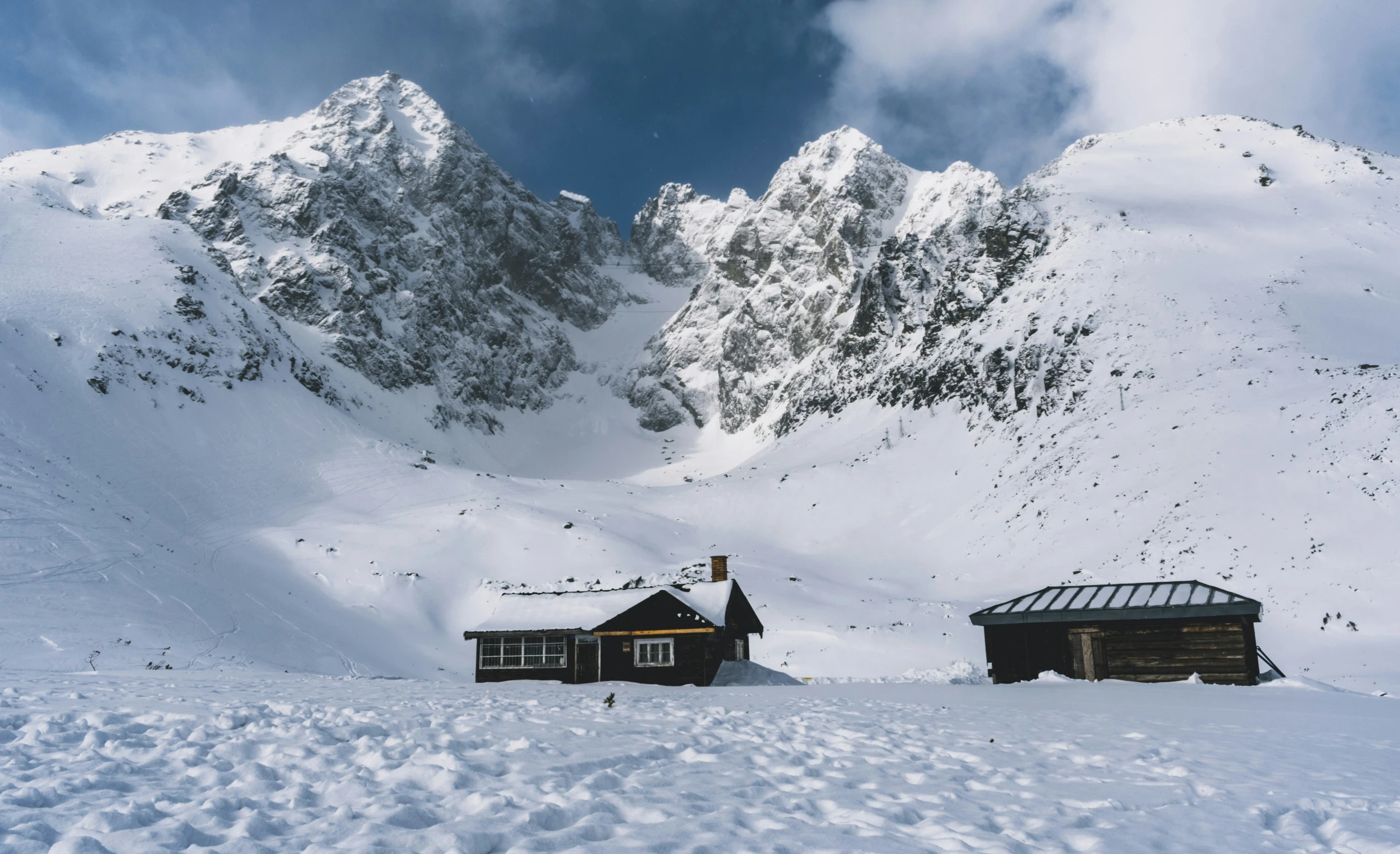 there are two cabin cottages on the snowy mountains