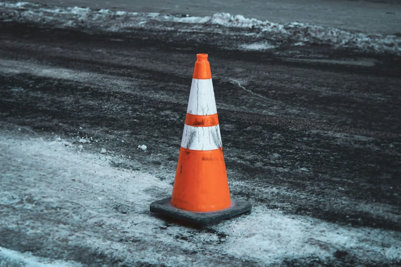 a street has a orange traffic cone on it