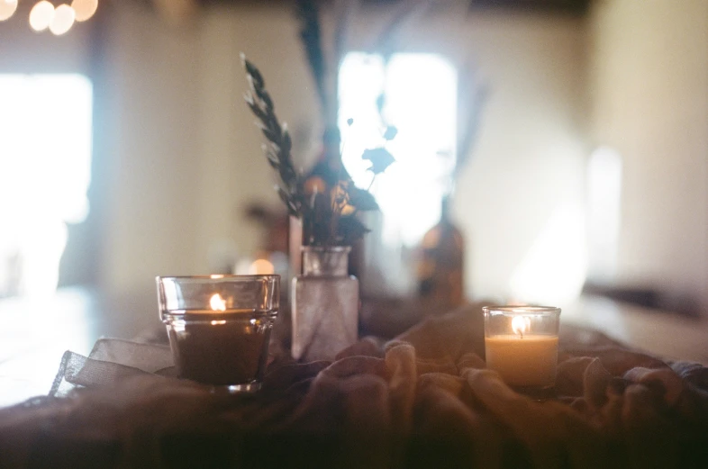 some lit candles and other things in vases