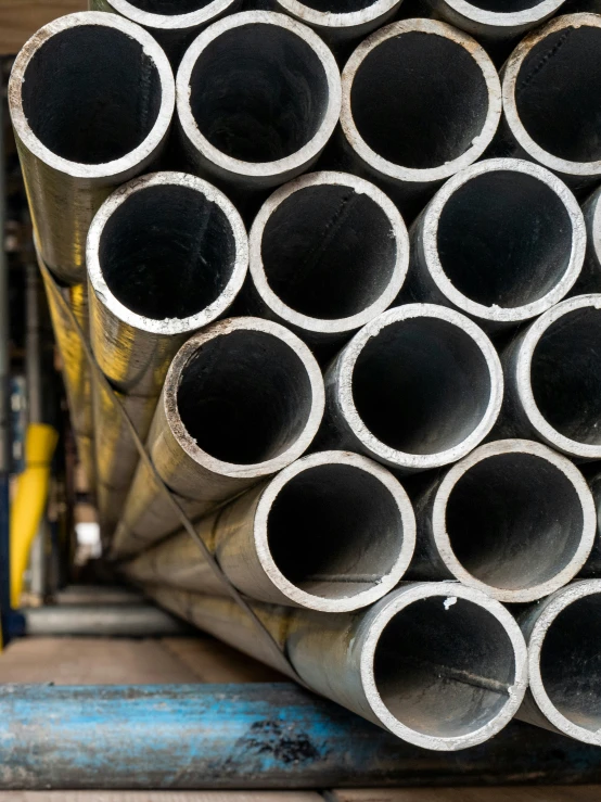 a pile of steel pipes with a man standing in front