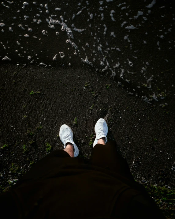 the feet of someone standing in front of water droplets