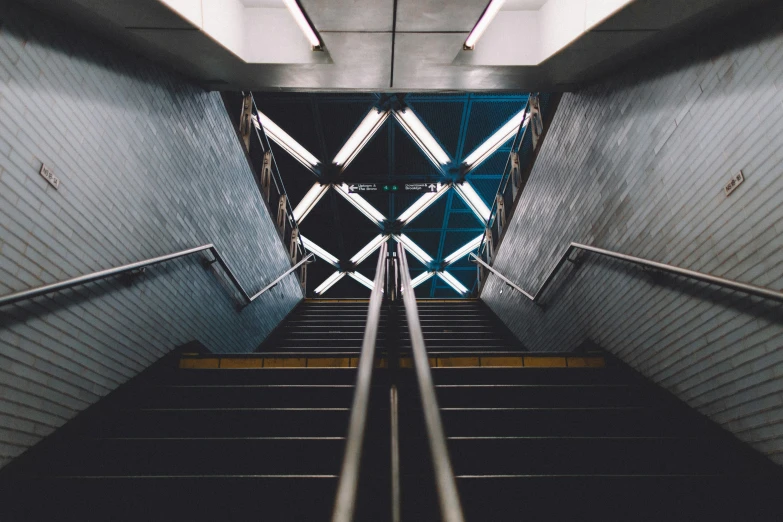 the top portion of an escalator in a building