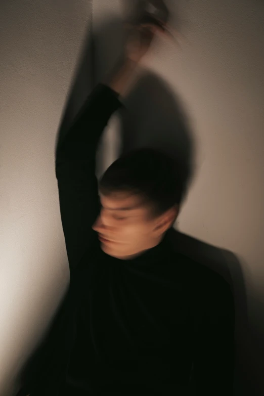 a man in a black top and white wall