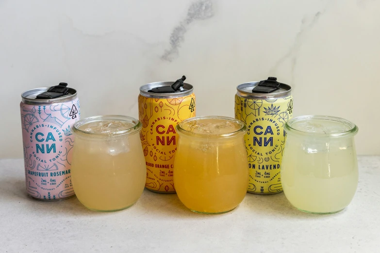 a row of four different colored drinks on a table