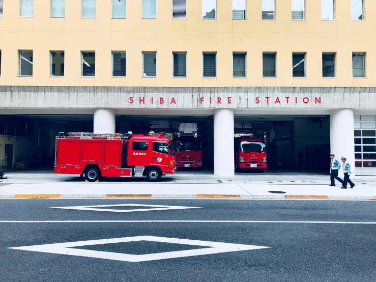 a fire station that has two red fire trucks outside