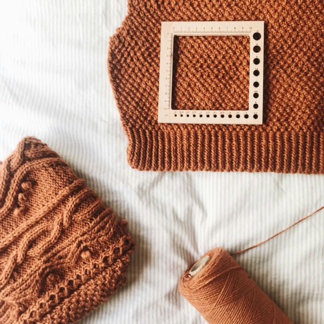 an empty knitting basket, with a needle, and yarn