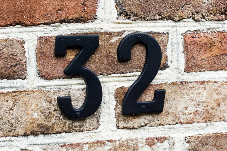 two numbers sitting on top of bricks with a brick wall behind it