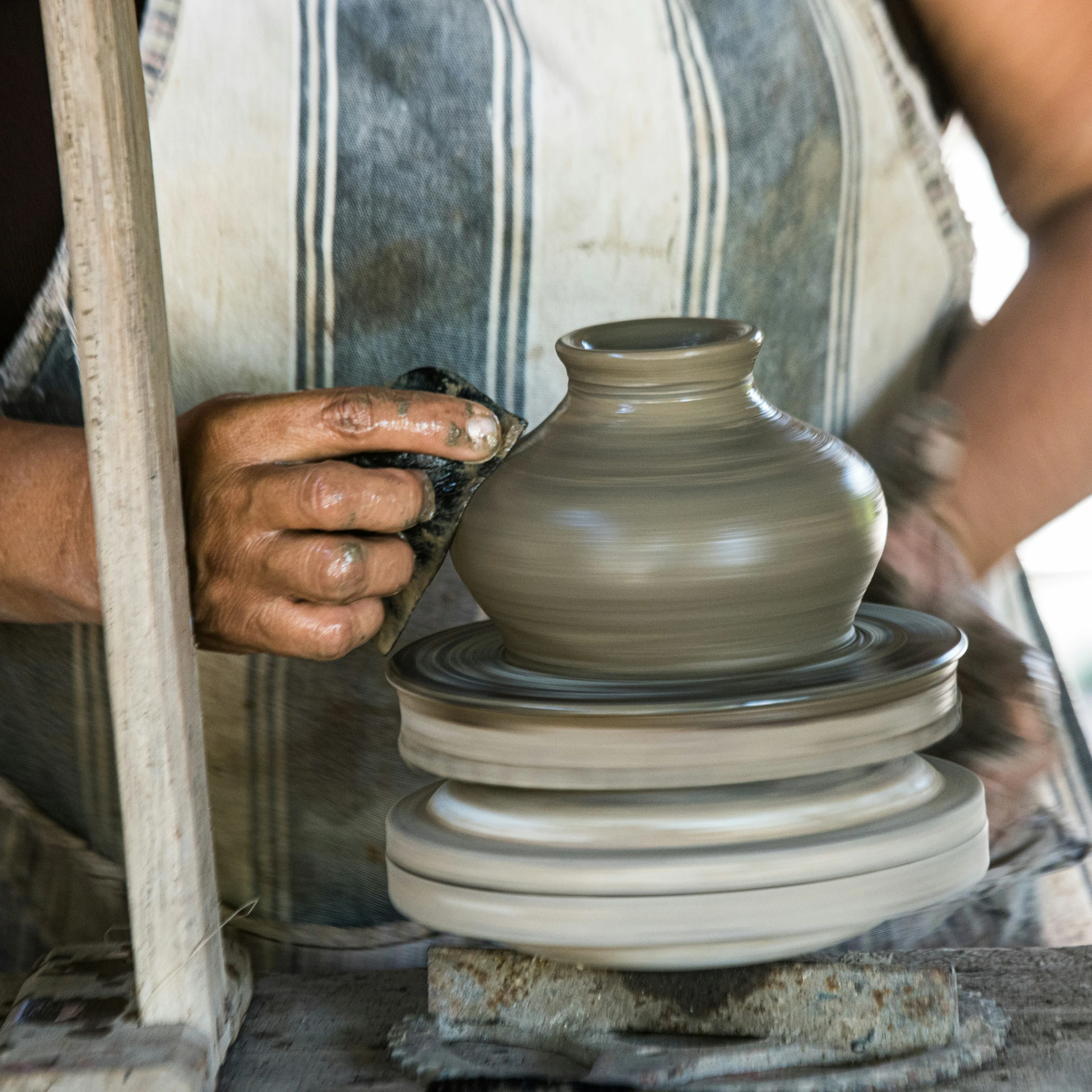 a woman who is arranging vases on top of a table