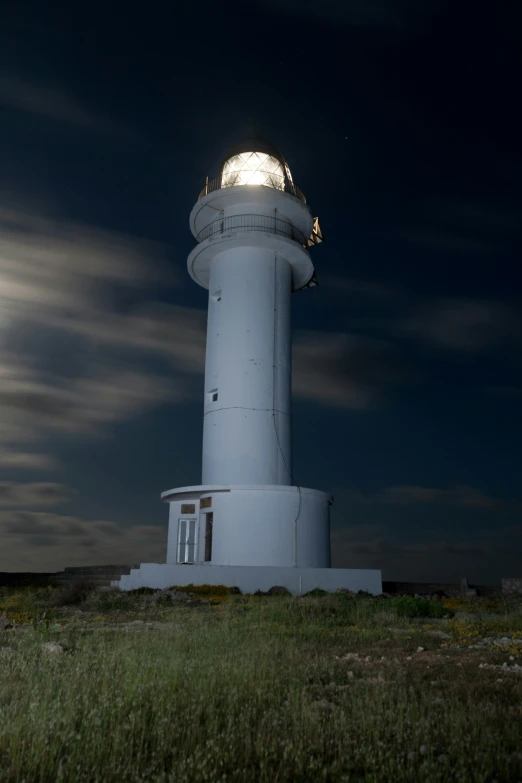 a large white lighthouse in the middle of a field