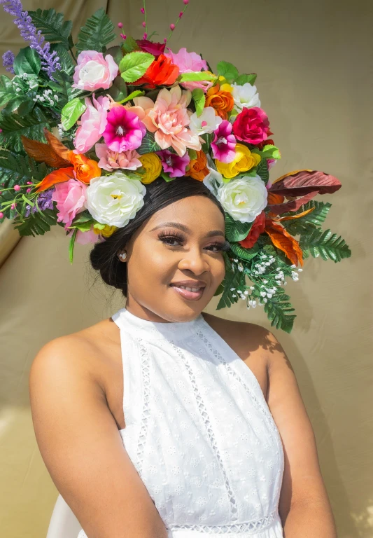 a woman standing on a beach wearing a flower crown on her head