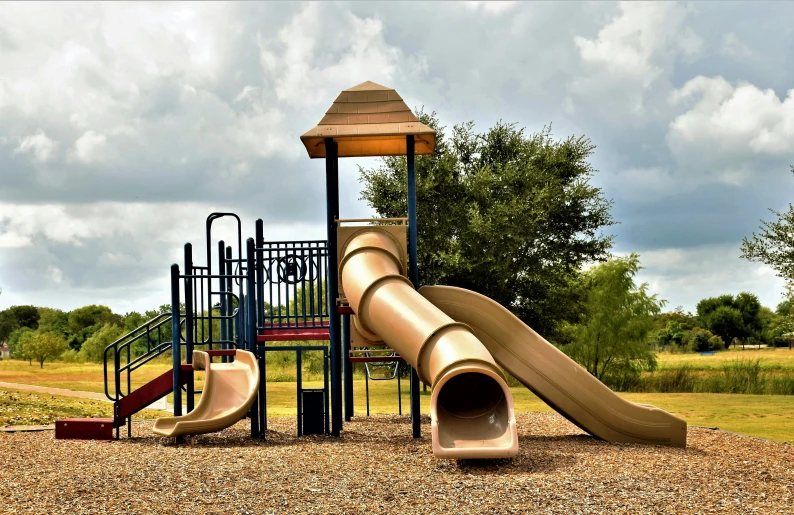 a play structure with a slide in a park