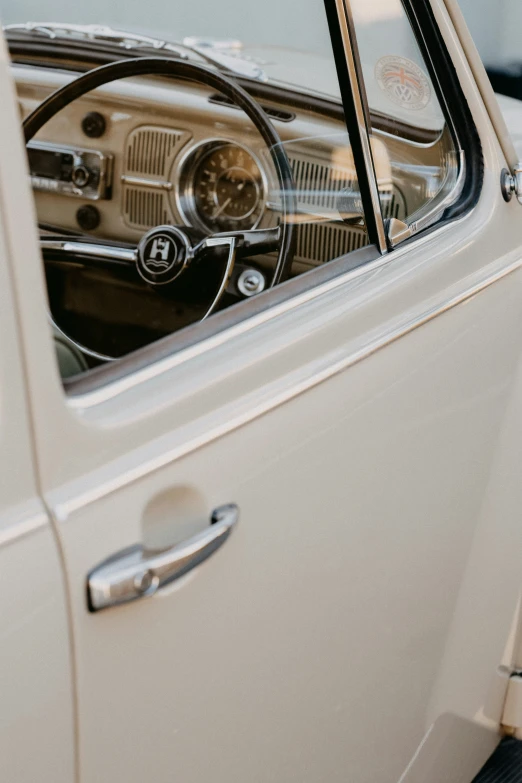 a close up of a car door with the dashboard and steering wheel seen through a window