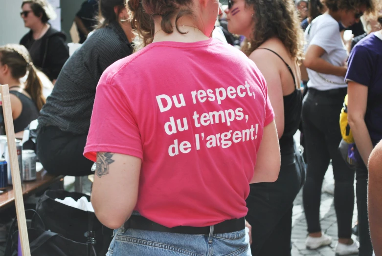 a person wearing a pink shirt and standing in front of other people