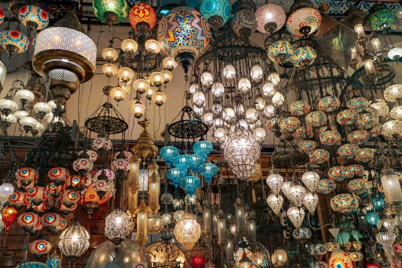 a huge selection of bright colored lamps and chandeliers hanging from the ceiling