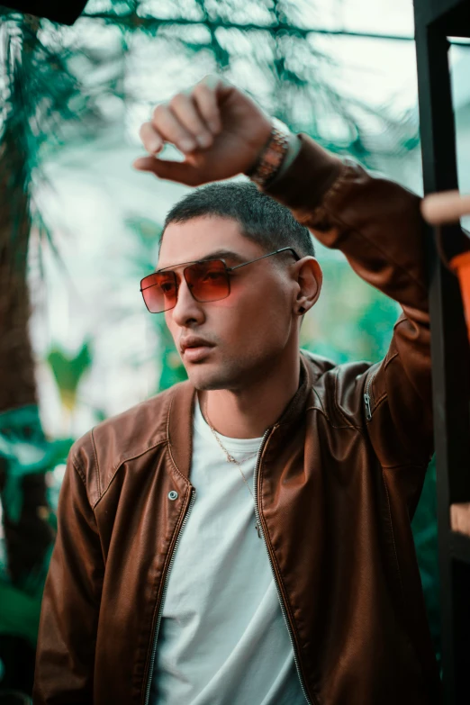 a young man posing for a picture while in an outdoor setting