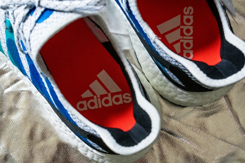adidas shoes sitting on a bed of cloth