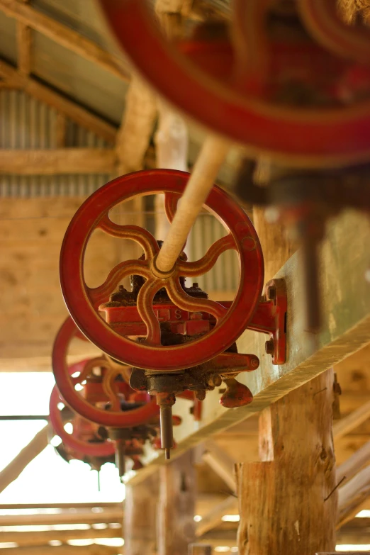 a clock with gears attached hanging on the ceiling