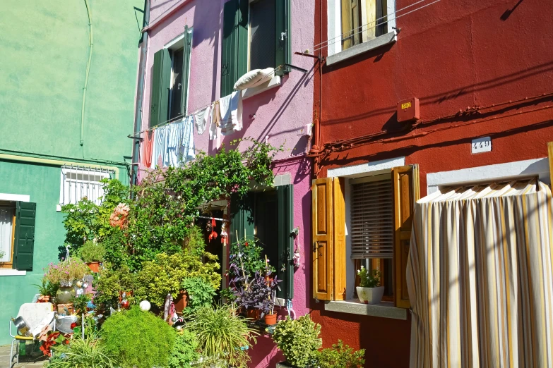 a pink and green building with several potted plants