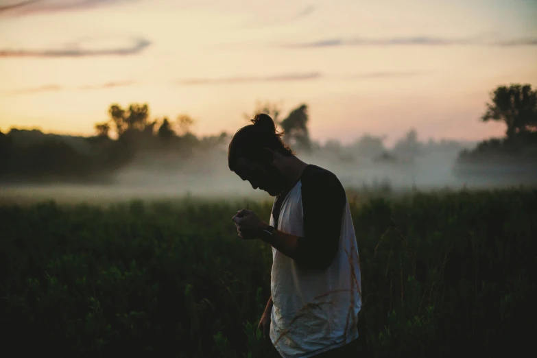 a person standing in a field with their phone