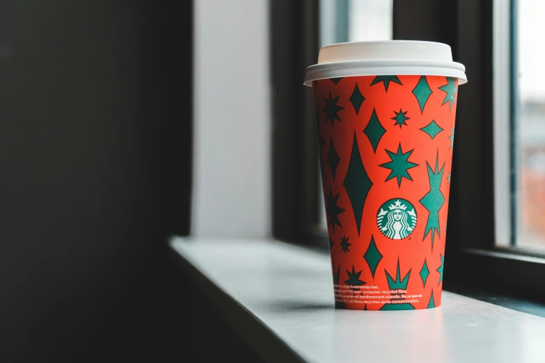 a starbucks cup with an orange and green background