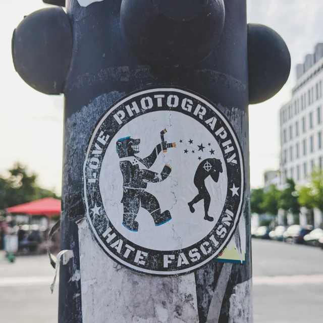 a sticker on a pole with a person holding soing