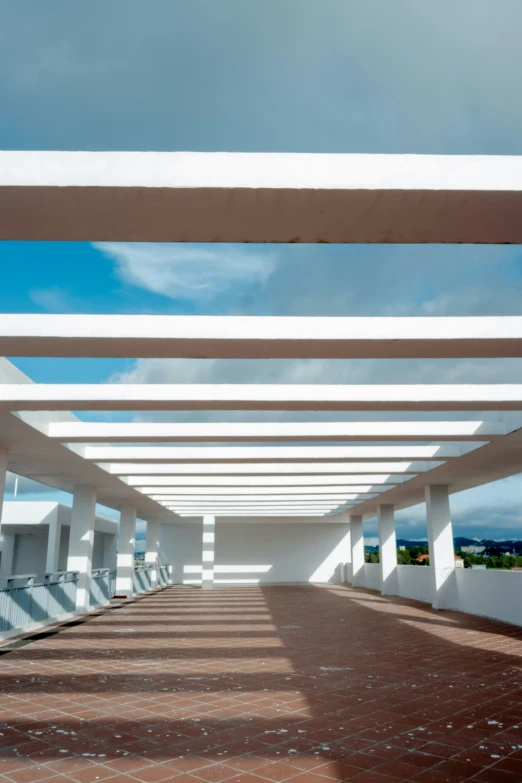 an empty walkway with benches along the length of it