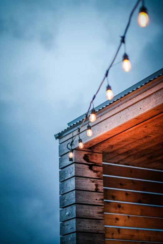 the top of a building with string lights hanging from it