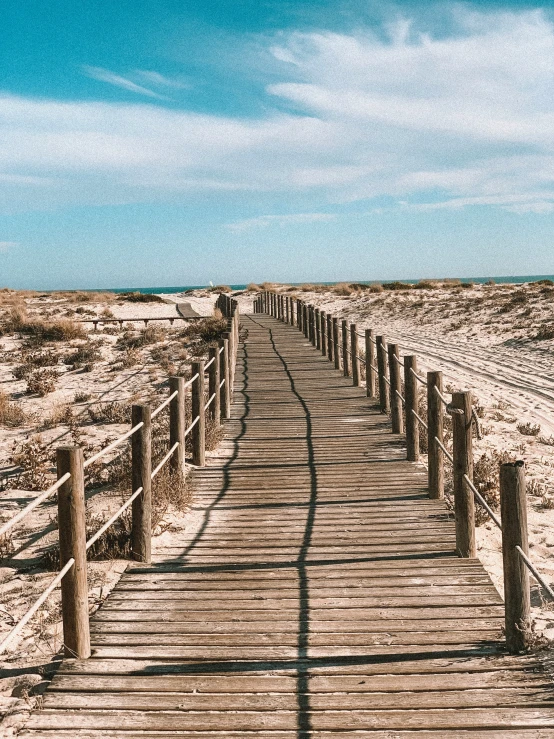 a wooden walkway in the middle of a desert