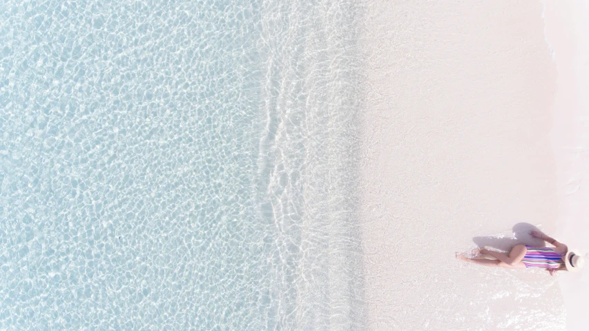 a group of people laying on top of a sandy beach