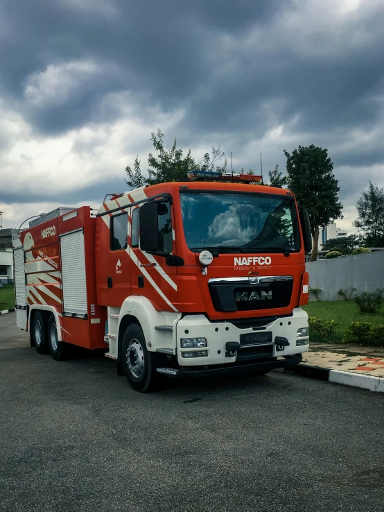 a red and white truck is parked next to a building