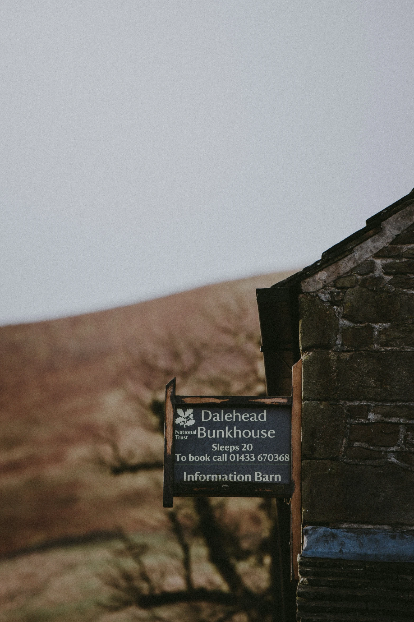 a building in a remote area with a sign next to it