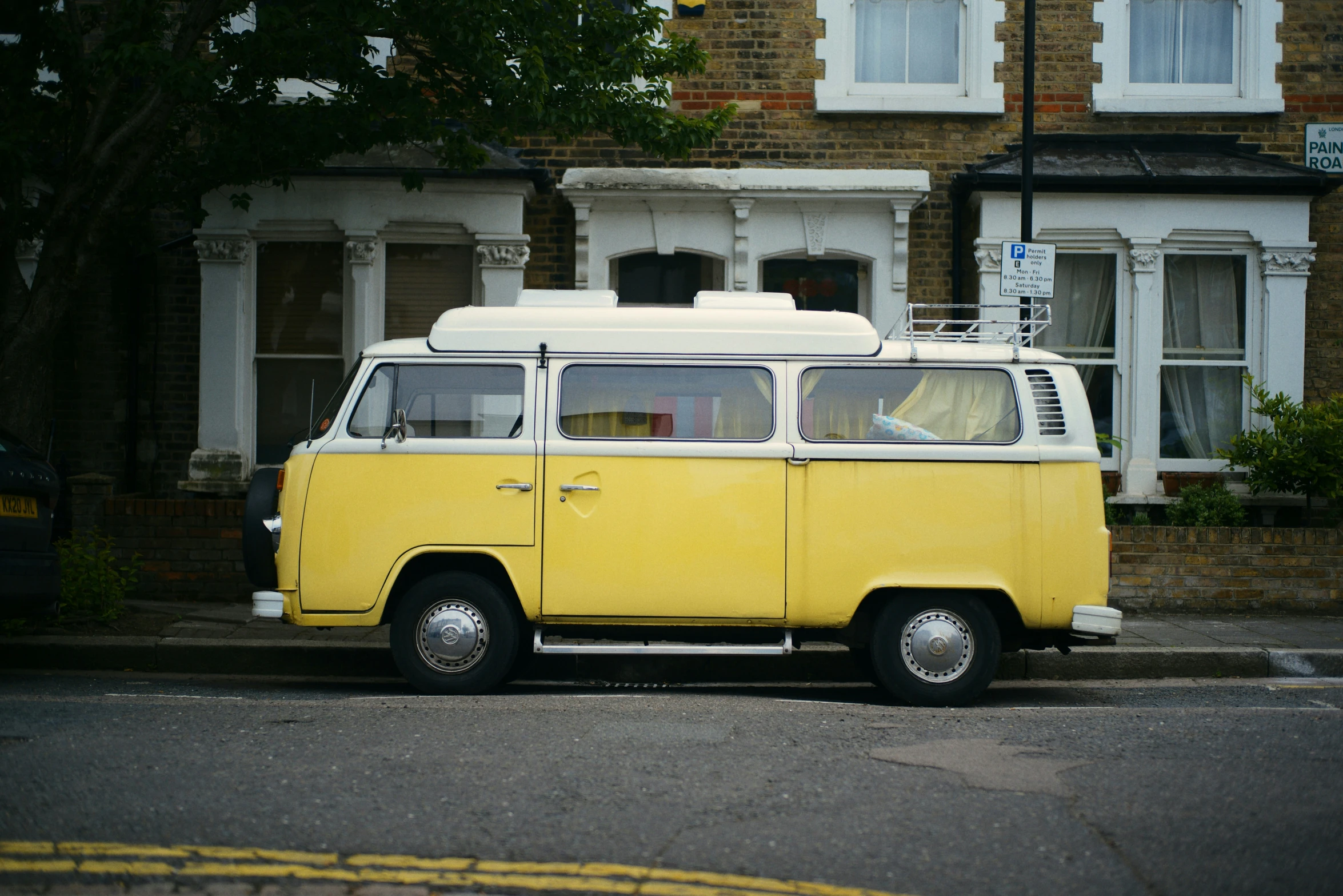 yellow vw bus in front of a building with white roof