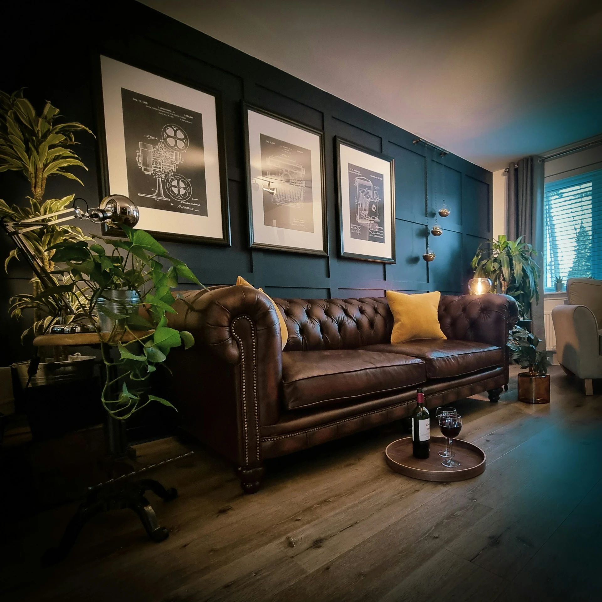 a dark room with couch, table and plants