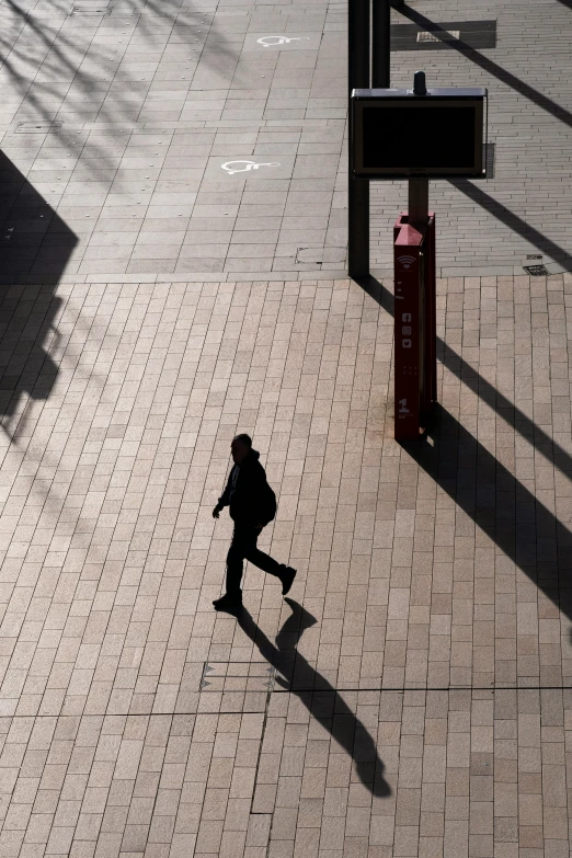 an aerial view of a person walking past a red sign post