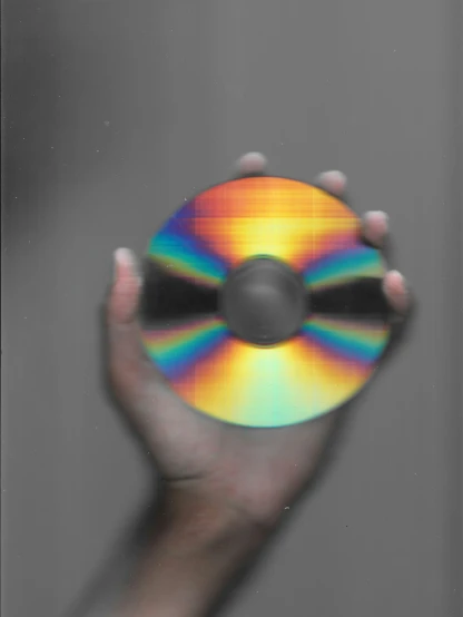 a hand holding up a multi - colored disc
