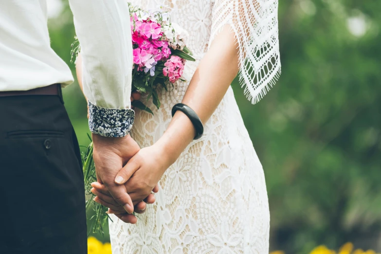 the bride and groom hold hands with each other