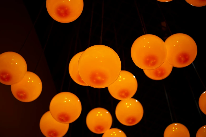 a bunch of orange balls hanging in the dark