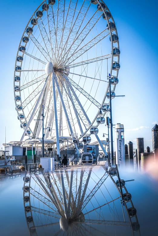 a ferris wheel is reflected in the water