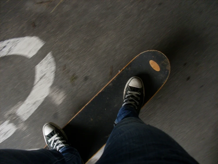 the legs of a person standing at the top of the skateboard