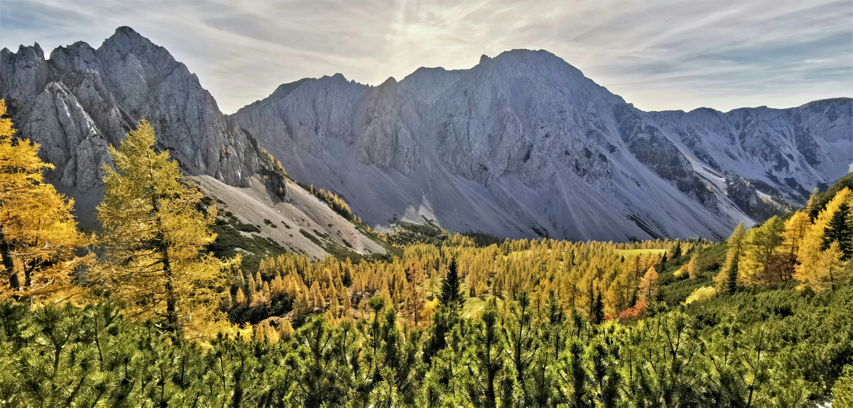 view of mountain peaks in autumn from the peak of the hill