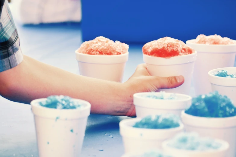 several containers of white cups with blue sprinkles