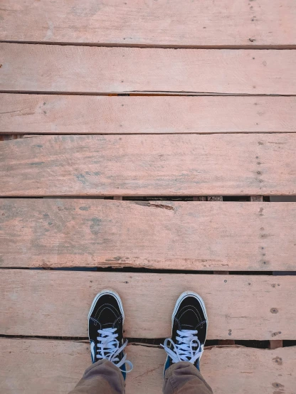 the feet of a person standing on a deck