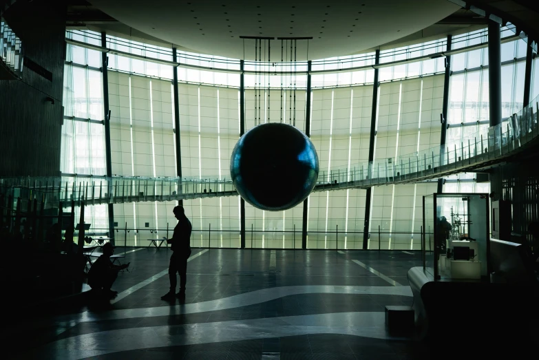 a man standing in a large hall with some lights on