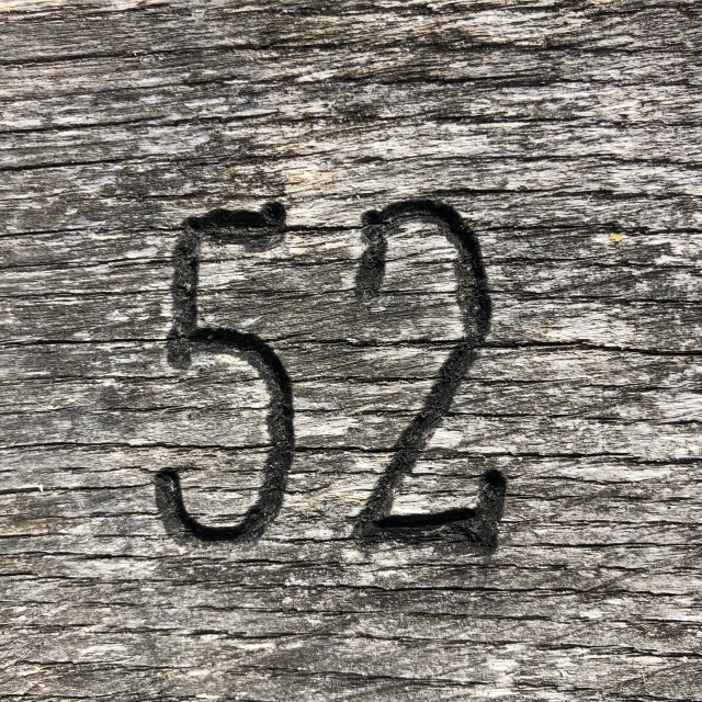 the number twenty five on a piece of wood with faded edges