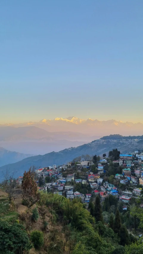 a hilly area in the foreground with a city in the background